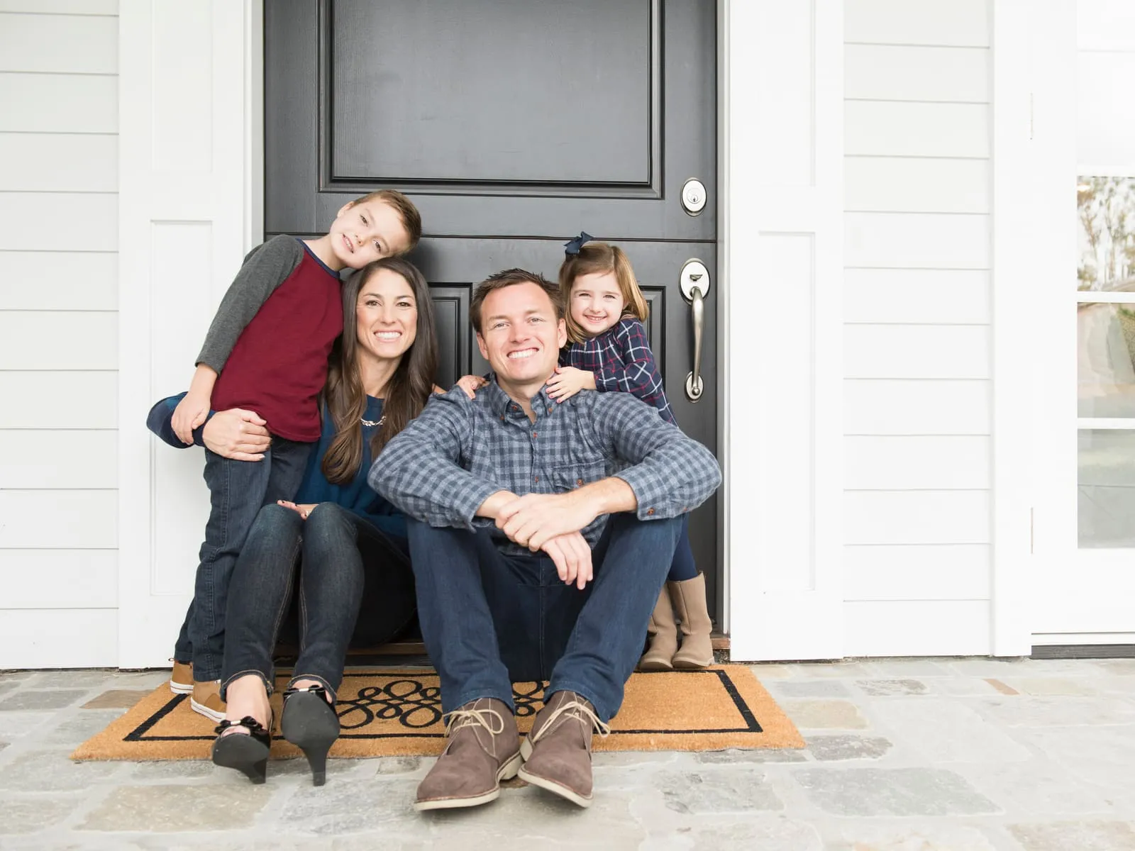 A family sitting together on the front porch of their home