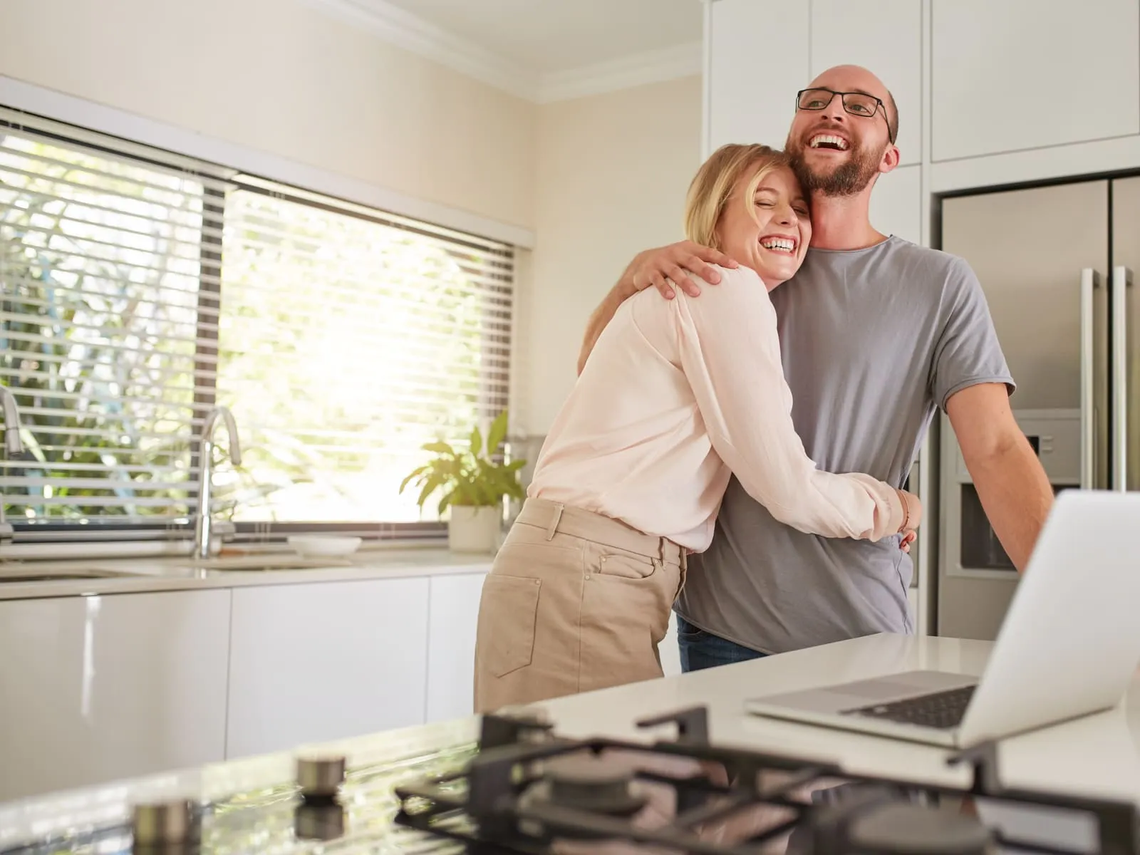 A couple hugging in their kitchen