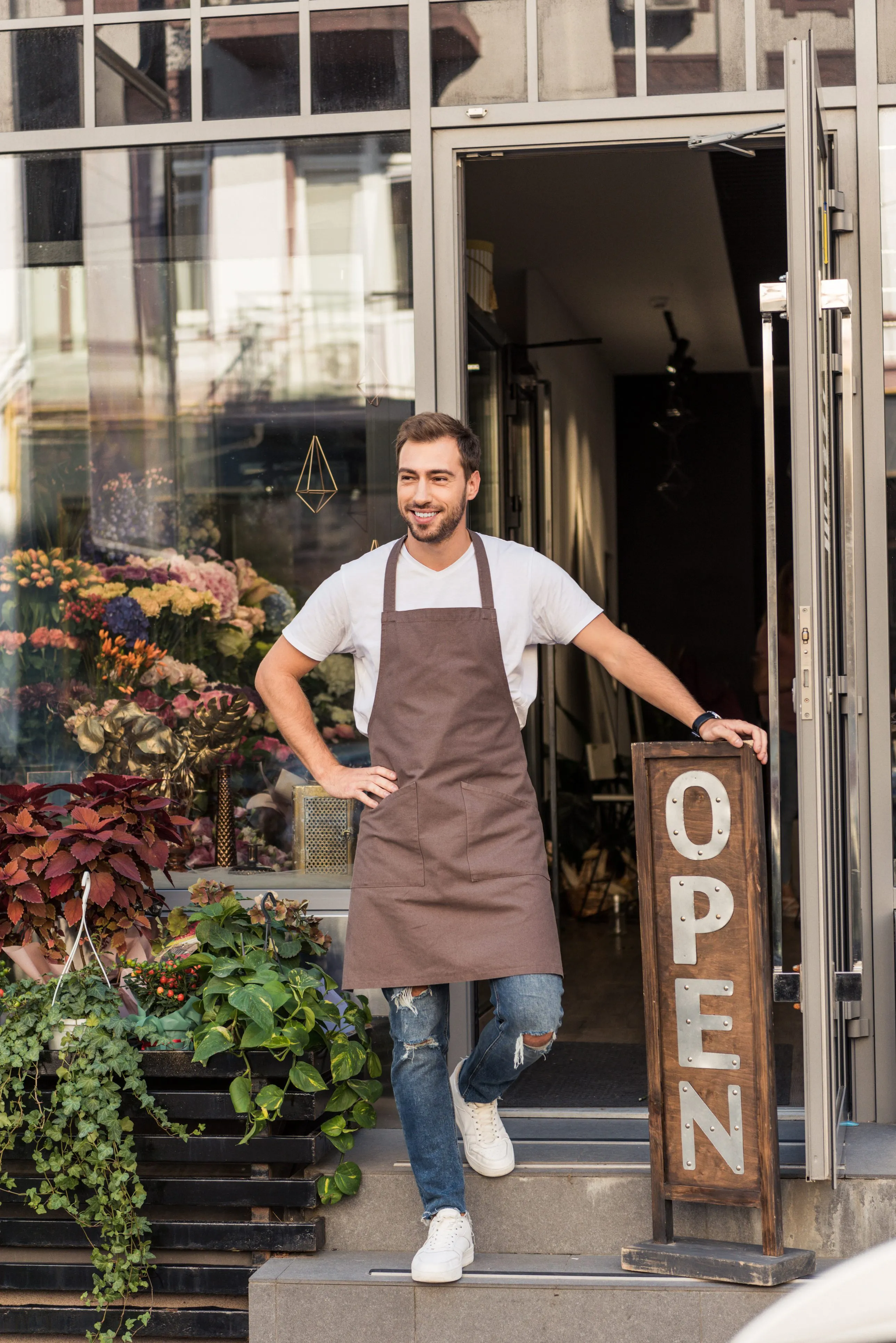 A cafe owner standing in the doorway of his shop