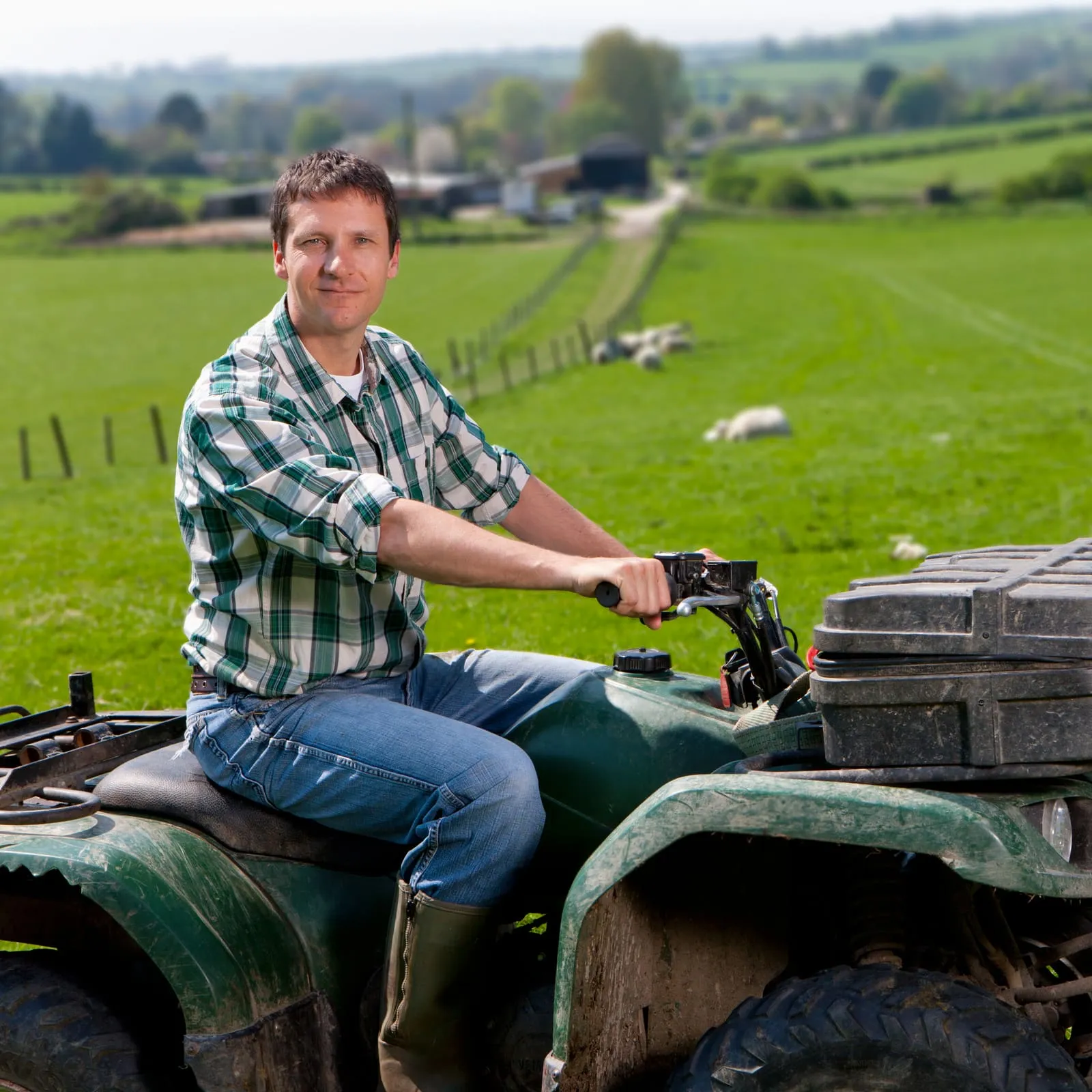 A farmer on a quad bike in a green paddock